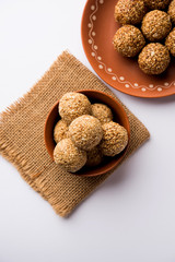 Tilgul Laddu or Til Gul balls for makar sankranti, it's a healthy food made using sesame, crushed peanuts and jaggery. served in a bowl. selective focus showing details.