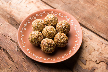 Tilgul Laddu or Til Gul balls for makar sankranti, it's a healthy food made using sesame, crushed peanuts and jaggery. served in a bowl. selective focus showing details.