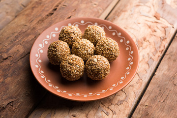 Tilgul Laddu or Til Gul balls for makar sankranti, it's a healthy food made using sesame, crushed peanuts and jaggery. served in a bowl. selective focus showing details.