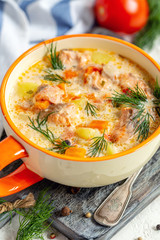 Creamy soup with salmon and vegetables in a bowl..