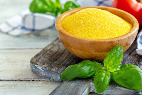 Uncooked Italian Polenta In A Wooden Bowl.