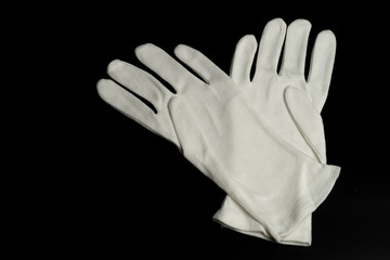Pair of white cotton gloves - isolated on black background
