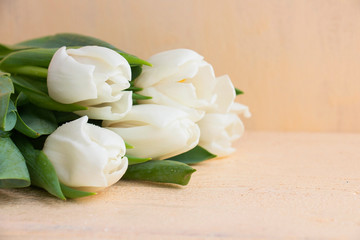 Obraz na płótnie Canvas white tulips present on a wooden table