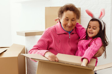 Mom grandmother and little girl open gift boxes repair apartment