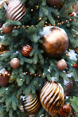 Obraz na płótnie Canvas Christmas decorations and toys on a green Christmas tree in the snow