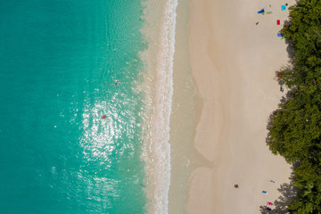Fototapeta na wymiar Aerial view of sandy beach with tourists swimming in beautiful clear sea water
