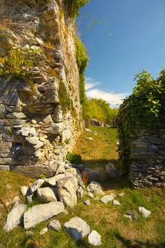 Stony wall falling into peaces, ruins of a former castel of Montousse, France
