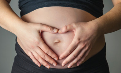 Unrecognizable pregnant woman caressing her belly