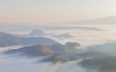 Mountain view morning of the hill around with the ocean of mist with blue sky background, sunrise at Tham Sakoen View Point attraction on route 1148, Tham Sakoen National Park, Nan, Thailand.