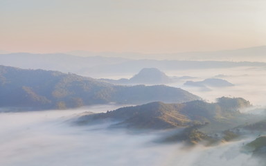 Fototapeta na wymiar Mountain view morning of the hill around with the ocean of mist with blue sky background, sunrise at Tham Sakoen View Point attraction on route 1148, Tham Sakoen National Park, Nan Province, Thailand.
