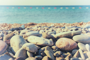 Fototapeta na wymiar Pebbles on the shore and the sea horizon