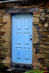 Rustic hand-hewn wood door set into a stone wall built from schist in Piodão, made of shale rocks stack, one of Portugal's schist villages in the Aldeias do Xisto.