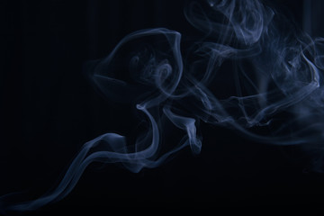 smoke wriggles around in different patterns on a black background.