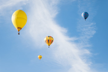 Multi colored hot air balloons flying over blue sky