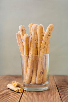 Grissini on wooden table. Traditional italian snack with herbs. Copy space. Vertical image.