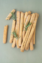 Grissini on grey table. Traditional italian snack with herbs. Copy space. Vertical image.