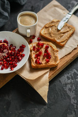 Sandwich with peanut paste and pomegranate grain red - breakfast or sweet snack (dessert). Top view. copy space