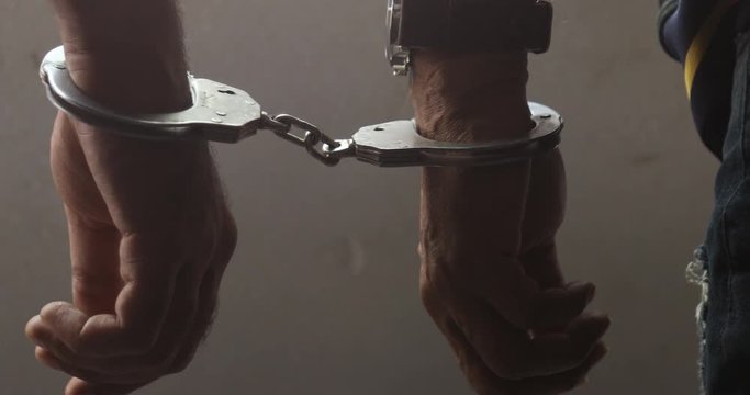 Male criminal Hands with police Handcuffs