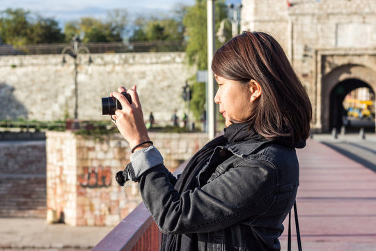Chinese Girl Standing on the Bridge and Taking Picture With Her Photo Camera