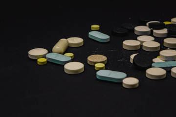 Pile of several medicines on black background