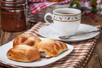Buns with berries on a wooden table.