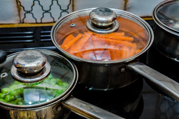 Carrots and peas boiling on he hob