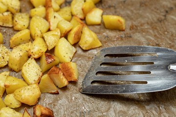 Baked potatoes sprinkled with spices. Vegetables cut into cubes prepared for serving on the table.