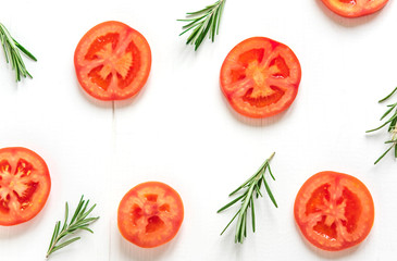 Slices of tomatoes on a white background. Frame for a banner with tomato and rosemary. White background with vegetables. View from above. Fresh tomatoes