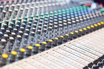 Audio sound mixer console with buttons and sliders. Selective focus