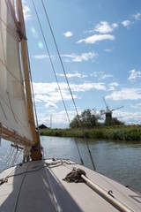 View from a sailing boat near a windmill / wind pump on the Norfolk Broads