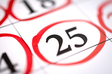 Red circle marked with pen on a calendar sheet 25 date