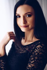 Brunette woman posing near window