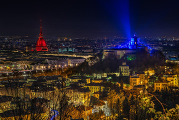 Scenic night cityscape of Turin with the Mole Antonelliana and Monte dei Cappuccini lighted in red and blue, Italy 