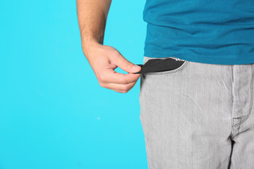 Man showing empty pocket on color background, closeup. Space for text