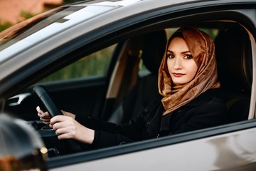 Fototapeta na wymiar Muslim woman in car as driver