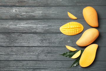 Flat lay composition with mango on wooden background. Space for text