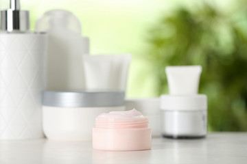 Jar of body care product on table against blurred background. Space for text