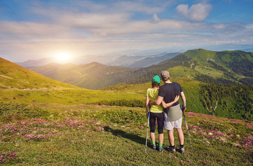 Fototapeta na wymiar couple of hikers with backpacks enjoying panoramic view