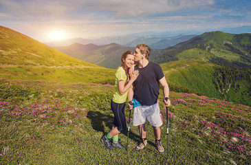 Couple in love kissing on nature travel hiking in Hawaii mountains. Young hikers people happy together.