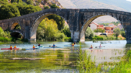 Fototapeta na wymiar People Kayaking Under Arslanagic (Perovic) Bridge in Trebinje, Bosnia and Herzegovina (04.08.2018)