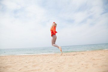 woman jumps into top and sandy sea Beach