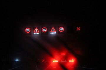 Traffic by night. Federal autobahn, stop lights and traffic signs. Speed limitation because of dust.  