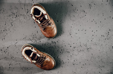 A pair of small leather shoe isolated on a dark stonel background. Warm, fur-lined children's shoes...