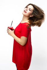 Obraz premium Healthy Lifestyle. Positive Smiling Girl Drinking Red Smoothie Juice Mix. Posing in Red Dress Over White Background.