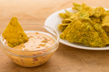 Dipping spicy jalapeno tortilla chips in chili con queso dip.