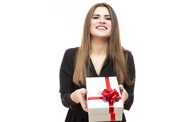 Fototapeta premium Celebrations Concepts. Portrait of Excited Caucasian Female Holding White Gift Box In Front Wrapped Up with Red Ribbon. Against White.