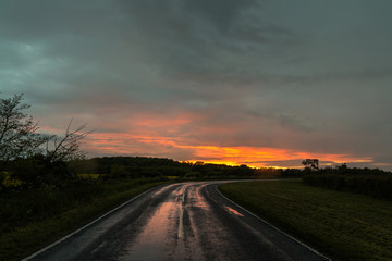 Obraz na płótnie Canvas Wet Road Bend At Sunset