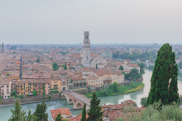 Fototapeta na wymiar Ponte Pietra over Adige river, with the bell tower of Verona cathedral and the historical center, in Verona, Italy