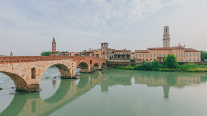 Ponte Pietra over Adige river, with the bell tower of Verona cathedral, in Verona, Italy