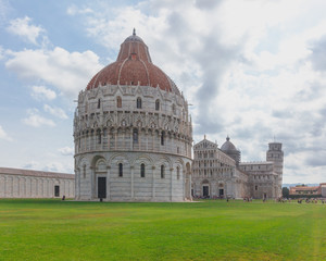 Pisa Bapistry and Cathedral over the lawn of Cathedral Square in Pisa, Italy